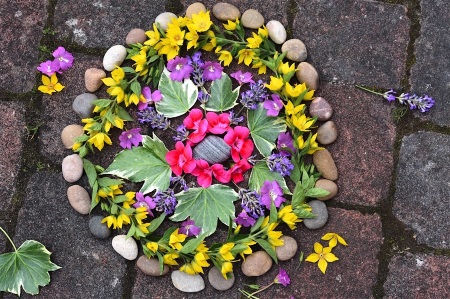 Mandala pattern made with flowers, leaves and pebbles